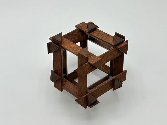 The RD Skeleton by Dubois is a beautifully crafted mechanical puzzle made from rich brown wood. Its design features a unique arrangement of wooden pieces forming a cube, with geometric shapes enhancing its structure. This intricate puzzle challenges your problem-solving skills while providing a visually appealing addition to any puzzle collection.