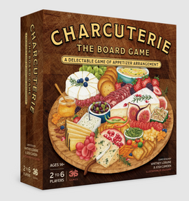 The box of 'Charcuterie: The Board Game' features a beautifully illustrated wooden serving board filled with various cheeses, meats, fruits, crackers, and dips. The title is prominently displayed in gold lettering at the top, and the game's details emphasize fun for 2 to 6 players aged 14 and older.