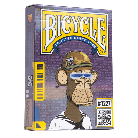 Bicycle Bored Ape playing cards from US Playing Card Co. featuring a cartoon monkey wearing a sailor outfit and glasses on the packaging. The box displays vibrant colors and graphics with the Bicycle logo at the top.