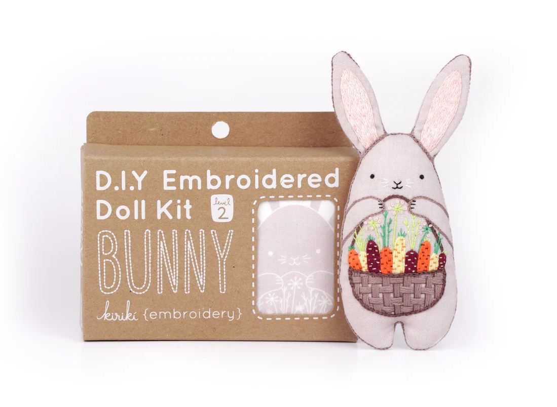 Bunny Doll Embroidery Kit by Kiriki Press. This DIY kit features a cute bunny character holding a basket of colorful vegetables. The packaging displays the instructions and kit level as 'level 2'. Perfect for embroidery enthusiasts looking for a fun and creative project.