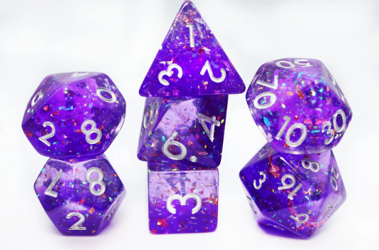 It's A Parade RPG Dice Set by Foam Brain Games, featuring a stunning assortment of polyhedral dice in vibrant shades of purple with glittery accents, including d4, d6, d8, d10, d12, and d20, perfect for tabletop gaming.