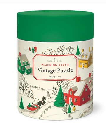 A short cylinder with a green lid and snowscape scene with red, green, and yellow houses, people in coats, and trees