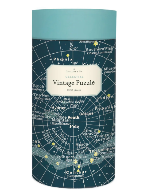 A cylindrical puzzle box for 'Vintage Puzzle' by Cavallini & Co. The box features a dark teal map design with white celestial lines and text, and a light teal top band.