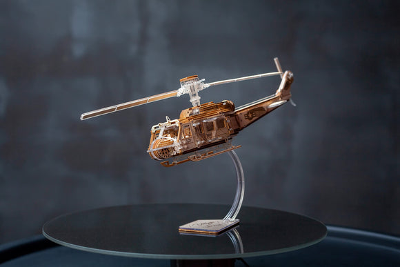 Detailed Veter Models Valkyrja DIY kit showcasing a finely crafted helicopter model. The model features intricate parts with a glossy finish, displayed on a sleek glass table against a dark background. Perfect for hobbyists and enthusiasts alike.