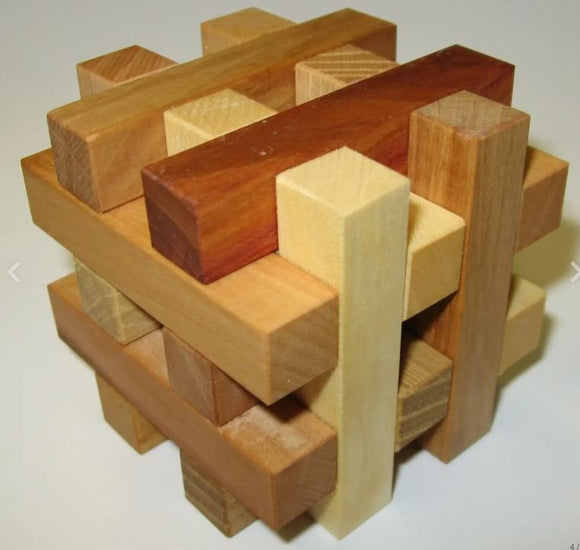 A detailed view of the 'Coming of Age' mechanical puzzle by VINCO, featuring an intricate arrangement of wooden pieces in various shades and textures, designed to challenge and engage users as they attempt to disassemble and reassemble the puzzle.