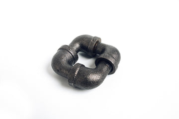 The Impossible Street Elbows by Here to There Companies is a unique mechanical puzzle shaped like intertwined pipe elbows, crafted from durable dark metal. It features a textured surface and intricate design, challenging users to figure out how to disassemble and reassemble the pieces in a fun and engaging manner.