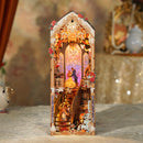 Enchanted Rose DIY Book Nook Assembled Front Facing showcasing household characters on a staircasing, a princess and hairy suitor dancing atop the stairs, a fireplace, chandeliere, and a red rose protected under a glass case