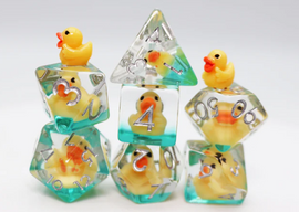 A colorful Rubber Duckie RPG Dice Set featuring whimsical yellow rubber duck figures encapsulated in clear resin dice. The set includes various polyhedral shapes, with the ducks visible within the transparent sides and playful teal accents. Perfect for tabletop gaming enthusiasts who enjoy a fun aesthetic.