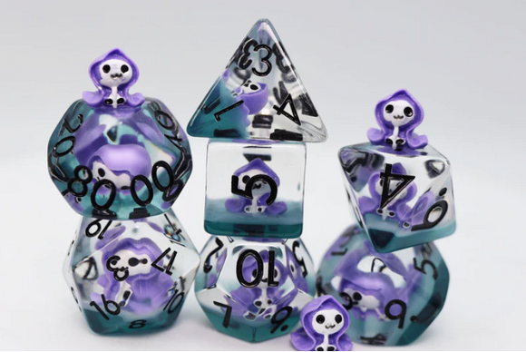 A vibrant Dream Reaper RPG Dice Set by Foam Brain, featuring various polyhedral dice in shades of purple and teal. Each die has intricate black numbering and is topped with small, cute skull characters, making them perfect for tabletop gaming enthusiasts.