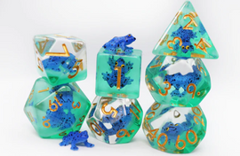 A beautifully crafted Dark Blue frog RPG dice set by Foam Brain. The set features various polyhedral dice with vibrant green translucent resin and intricate blue frog designs. Each die is marked with golden numerals, making them ideal for tabletop gaming.