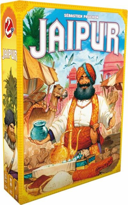 The box cover of the game 'Jaipur' (New Edition) by Space Cowboys. The artwork features a merchant in traditional attire holding a pot, with a vibrant market scene including camels and colorful tents in the background. The title 'JAIPUR' is prominently displayed at the top.