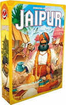 The box cover of the game 'Jaipur' (New Edition) by Space Cowboys. The artwork features a merchant in traditional attire holding a pot, with a vibrant market scene including camels and colorful tents in the background. The title 'JAIPUR' is prominently displayed at the top.
