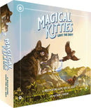 The box of 'Magical Kitties Save the Day!' features whimsical illustrations of adorable cats with magical powers, set against a scenic landscape. The title is prominently displayed in bold, playful font, and the tagline indicates it is a roleplaying game suitable for all ages.