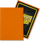 A pack of 100 Matte Orange Dragon Shields card protectors. The front features a vibrant orange color, while the reverse shows the Dragon Shield logo in black and yellow. Ideal for protecting trading cards.