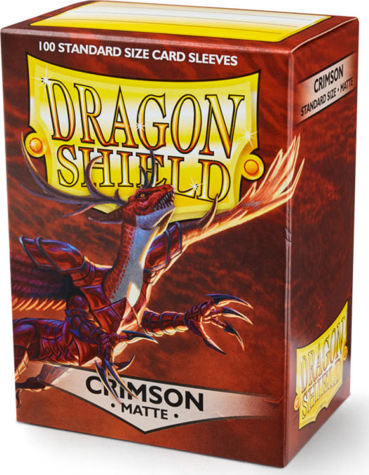 A pack of Dragon Shields card sleeves featuring 100 standard size matte crimson sleeves. The packaging showcases a vibrant dragon illustration with the product name 'Dragon Shield' prominently displayed.