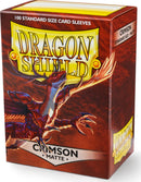 A pack of Dragon Shields card sleeves featuring 100 standard size matte crimson sleeves. The packaging showcases a vibrant dragon illustration with the product name 'Dragon Shield' prominently displayed.