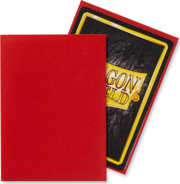 A pack of Dragon Shields in Matte Crimson color. The package displays a shiny black back with a vibrant yellow border, clearly featuring the Dragon Shield logo. The front of the pack showcases a smooth, matte crimson shield, perfect for protecting game cards.