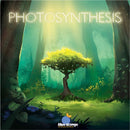 The game 'Photosynthesis' by Blue Orange U.S.A. features a beautifully illustrated cover showing a vibrant forest with a glowing tree at the center, surrounded by lush greenery and dappled sunlight filtering through the trees. The title is prominently displayed at the top with the brand logo at the bottom.