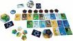 An assortment of colorful game cards and pieces from the Planet game by Blue Orange U.S.A. The layout includes hexagonal and circular tokens, alongside various illustrated cards depicting vibrant landscapes, animals, and elements of nature, designed for strategic gameplay.