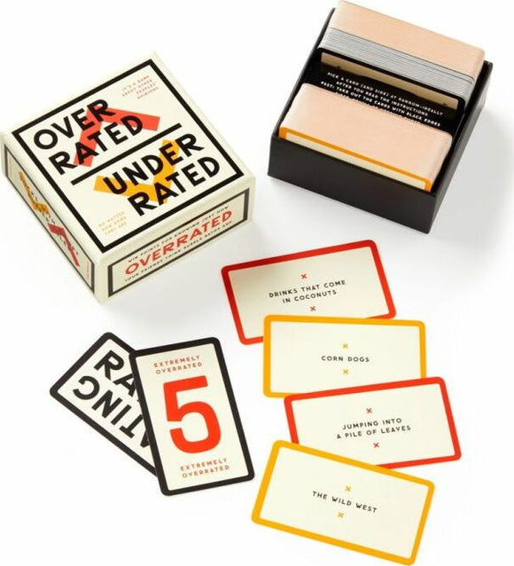 Overrated/Underrated Social Game by Brass Monkey displayed with its box and several game cards. The box features bold, colorful text, clearly labeled as 'OVER RATED' and 'UNDER RATED'. Laid out beside it are cards with phrases such as 'drinks that come in coconuts' and 'corn dogs', showcasing the fun, engaging nature of the game. Ideal for social gatherings.