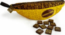 Bananagrams Signature Edition game featuring a yellow banana-shaped pouch with a zipper. The pouch is adorned with a brown pattern and the Bananagrams logo. Surrounding the pouch are brown letter tiles used for gameplay.
