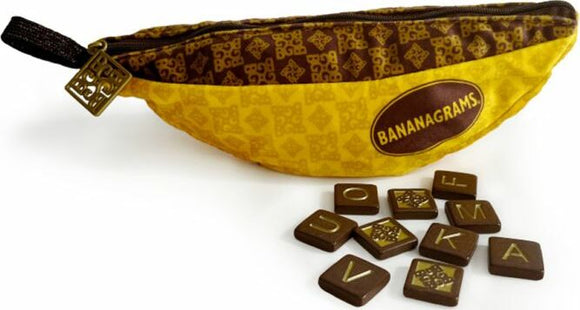 Bananagrams Signature Edition game featuring a yellow banana-shaped pouch with a zipper. The pouch is adorned with a brown pattern and the Bananagrams logo. Surrounding the pouch are brown letter tiles used for gameplay.