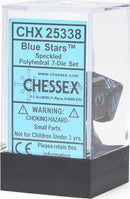 A speckled blue stars polyhedral dice set from Chessex, featuring seven intricately designed dice packaged in a clear plastic display box. The dice are displayed clearly within the box showing their unique celestial design and numbers, perfect for tabletop games.