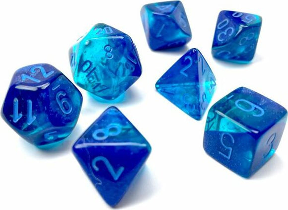Chessex Gemini blue and light blue luminous polyhedral dice set. The set includes various shapes, featuring transparent blue material with engraved white numbers, perfect for tabletop games.