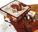 The Tsuro game by Calliope is beautifully presented with a striking dragon design on the box. The contents include game pieces in various colors, rule cards, and a richly decorated game board featuring intricate artwork. The packaging emphasizes a blend of cultural themes, making it visually appealing.