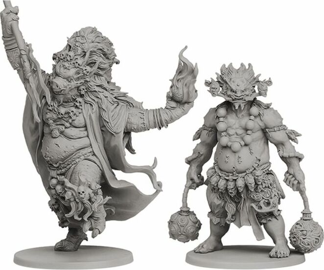 Two intricately designed game figurines depicted in gray scale. The left figurine features a robust character with flowing hair, adorned with skulls, raising one arm, while the right figurine is slightly smaller, featuring a squat character with a fish-like head and tribal accessories, holding a large mace. Both figures are set on circular bases, showcasing a fantasy theme.