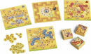Savannah Park game by Capstone Games, featuring multiple colorful game boards and hexagonal tiles. The boards depict an African savannah landscape with animal illustrations, while the tiles include various animal symbols and tokens. The game offers strategic gameplay as players aim to place their tiles wisely to score points.