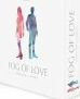 The game Fog of Love by Hush Hush Projects USA is displayed in its packaging. The box features vibrant illustrations of a couple in profile, one in pink and the other in blue, symbolizing a romantic theme. The title, 'Fog of Love', is prominently printed in modern font on the front of the box, with a clean white background that emphasizes the artwork and branding.