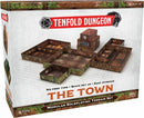 The Tenfold Dungeon: The Town game by Gale Force 9 features a modular roleplaying terrain set. The box displays a variety of intricately designed structures including a central clock tower and various building layouts that allow quick setup, no prep time, and easy storage for dynamic gameplay.