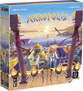 The Akropolis game box by Gigamic features a vibrant illustrated scene of ancient Greek architecture, with columns, a sunset over the sea, and players depicted in front. The design showcases rich colors such as golden domes and blue waters, inviting players to immerse themselves in a strategic building game. Suitable for ages 8 and up, it offers engaging gameplay for 2 to 4 players.
