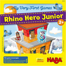 The box of Rhino Hero Junior by HABA features colorful illustrations and characters on a vibrant yellow background. It highlights a multi-story building with various animal characters, including a rhino in a cape, all set in a playful theme designed for young children aged 2 and up. The game encourages fine motor skills and understanding of basic counting and rules.