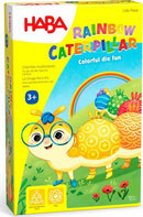 The Rainbow Caterpillar game box features a colorful illustration of a cartoon caterpillar wearing glasses, surrounded by vibrant flowers and a rainbow. Designed for children aged 3 and up, the packaging highlights its fun, engaging gameplay centered around colorful dice. The bright colors and friendly characters make it appealing to young players.