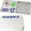 The Sequence Travel Classic game by Goliath, featuring a compact game board with a grid displaying numbers and letters, colorful chips, and playing cards. The items are neatly arranged, showcasing the game's travel-friendly design for easy portability.
