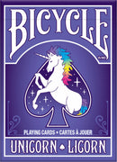 Bicycle Unicorn playing cards featuring a colorful unicorn with a rainbow mane on the front of the deck, set against a purple background with sparkling stars. The design includes 'Bicycle' in bold white lettering at the top, and 'Unicorn' in playful font at the bottom, highlighting its whimsical theme.