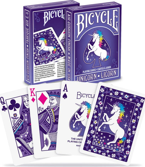 Bicycle Unicorn playing cards featuring a vibrant purple deck with a majestic unicorn illustration on the back. The front displays the Queen of Clubs, King of Diamonds, and Ace of Spades, highlighting the whimsical design and air cushion finish that ensures smooth gameplay.