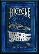 Bicycle Back to the Future playing cards featuring a design inspired by the iconic DeLorean time machine. The card box showcases a stylized silver and blue graphic with the movie title and 'Powered by Flux Capacitor' text.