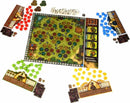 A colorful board game setup featuring a detailed game board with green and brown areas depicting a garden. Four sets of game pieces in red, blue, yellow, and green surround the board, along with player boards and tokens. The game components include various tokens and cards, enhancing the interactive gameplay experience.
