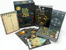 The Light in the Mist game by Postcurious featuring an intricately designed box. The package includes a tarot-themed journal, beautifully illustrated tarot cards, and a guidebook with a mystical forest scene. The cards display detailed artwork with symbols and imagery related to the tarot, inviting players to explore themes of mystery and adventure.