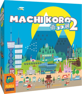 The box cover of Machi Koro 2 game by Pandasaurus Games, featuring a vibrant illustration of a colorful cityscape with various buildings, mountains in the background, and a bright sun. The title is prominently displayed at the top in bold letters.