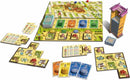 An image of the Alhambra board game set up for play. The game features a colorful board depicting the Alhambra, with cards, tiles, and wooden pieces arranged around it. There are various player cards showcasing buildings, currency, and scoring options, along with a tall tower piece representing the game's mechanics.