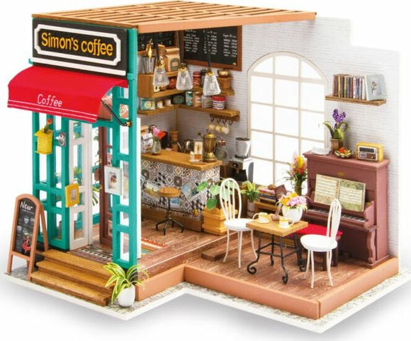 A detailed mini model of Simon's Coffee shop, featuring a charming exterior with a red awning and welcoming entrance. Inside, there's a well-equipped coffee counter, seating area with tables and chairs, a piano, and decorative plants, creating a cozy café atmosphere.