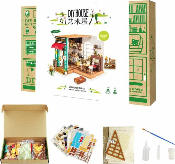 The Simon's Coffee Model Kit by Robotime, showcasing a beautifully designed DIY coffee shop model. The kit includes various pieces, tools, and decorative elements to build an intricate miniature coffee house. The packaging features an illustration of the completed model with vibrant colors and detailed features, and additional materials are displayed nearby.
