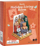 A detailed image of the DIY Holiday Living Room kit by Robotime, featuring a cozy miniature setup with a teddy bear in a checkered chair, a red side table with a cake, decorative pictures on the wall, and various accents that create a warm and inviting atmosphere.