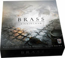 Brass: Birmingham board game box by Roxley Games featuring an artistic design. The box shows cobblestones and historical elements, with the title 'BRASS' prominently displayed. The names of the creators Matt Tolman, Martin Wallace, and Gavan Brown are featured at the bottom.