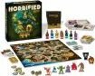 The game 'Horrified: American Monsters' by Ravensburger displayed with its game board, miniatures, cards, and components. The box features vibrant artwork showing classic American monsters, accompanied by a detailed game board depicting various locations. The set includes sculpted miniatures representing iconic creatures, game cards for action and strategy, and additional game elements to enhance play.