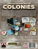 Back cover of Terraforming Mars: Colonies game by Stronghold Games. The image displays game contents including project cards, corporation cards, colony tiles, trade fleets, and game rules. A summary of the game's theme about expanding operations into the solar system and colonizing planets is highlighted. The design features various graphics representing game elements and gameplay.